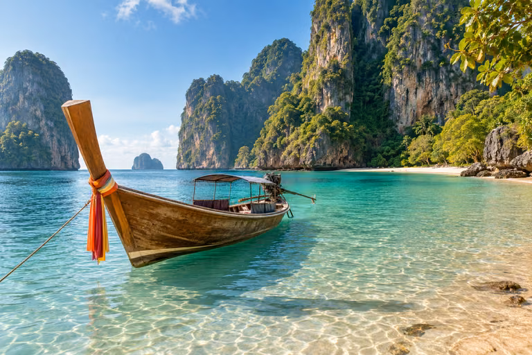 เรือหางยาวในทะเลใสกับหน้าผาหินปูน